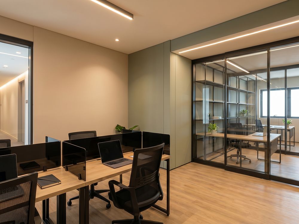 Coworking com mesas, cadeiras e sala de reunião envidraçada