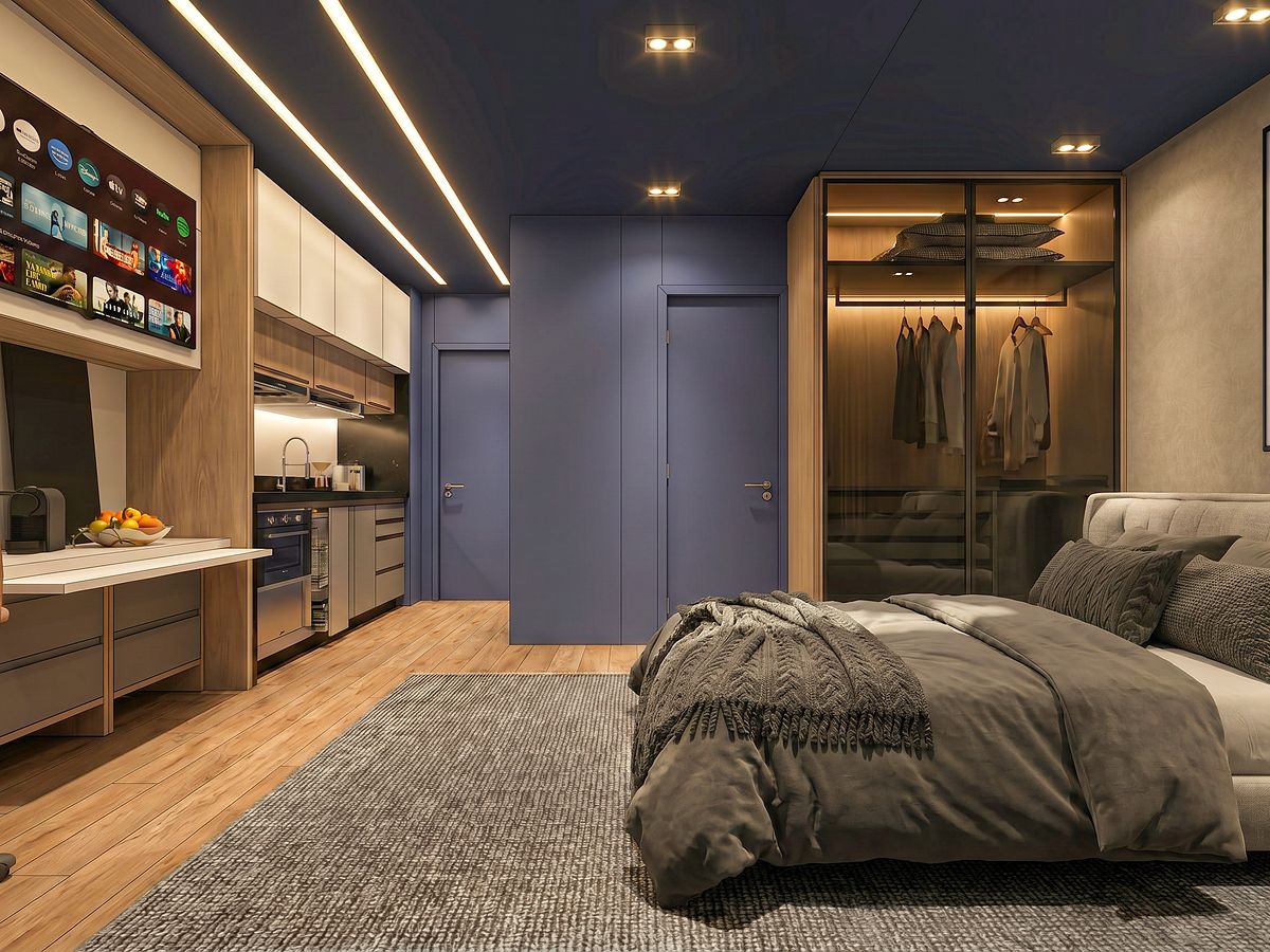 Studio decorado com cama de casal, armário com porta de vidro e cozinha integrada